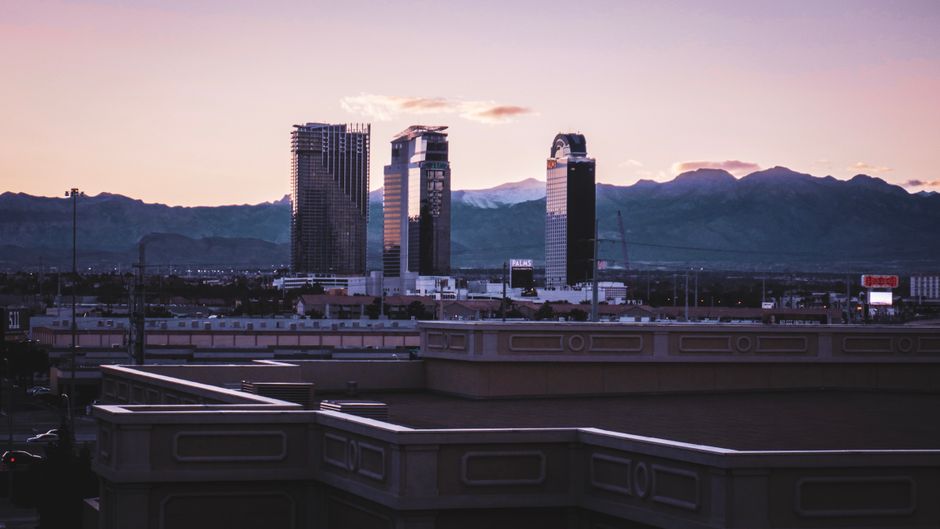A city skyline with skyscrapers at twilight and distant mountains creating a serene urban landscape.
